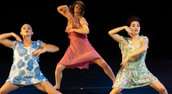 Three women in floral dresses dancing