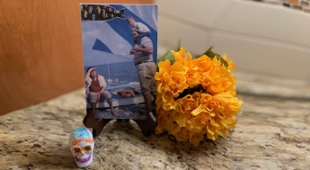 A collage next to a sugar skull and yellow flowers