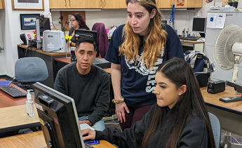 Student at a computer receiving enrollment help from an LAMC representative