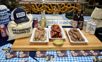 A spread of Oktoberfest food and beer, including sausage and pretzels