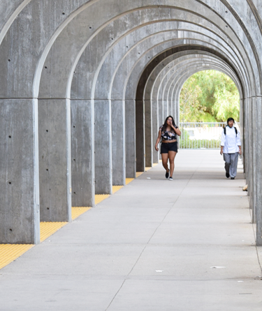 Students walking through arch structures