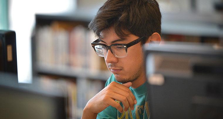 Student Wearing Glasses Using a Computer
