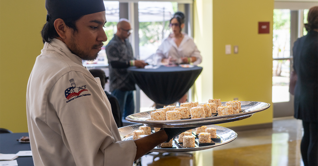 Culinary student delivering a tray of Hors d'oeuvres