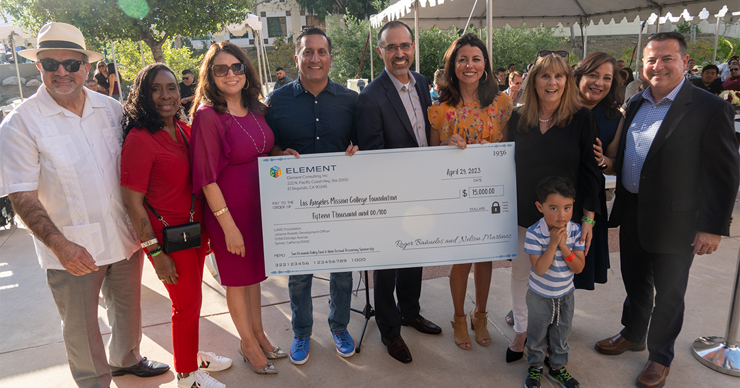 A group of people holding a giant check for $15,000 at the San Fernando Valley Food & Wine Festival