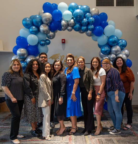EOPS Staff standing in front of a blue palette balloon arc