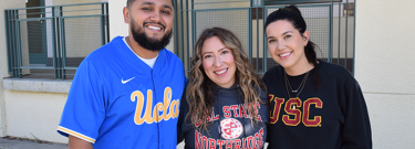 Three staff members wearing a UCLA jersey, a CSUN sweater, and a USC shirt