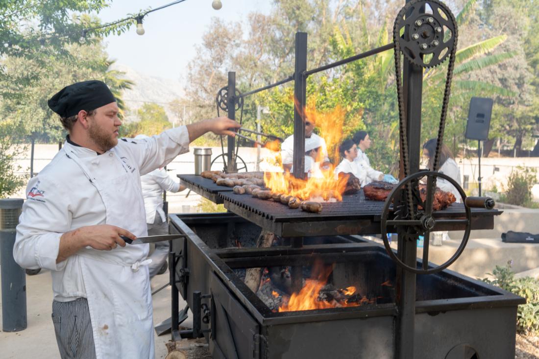 Culinary students cooking on outdoor flame bbq